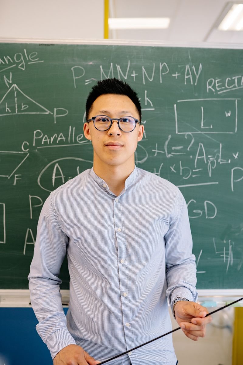 Rajesh Sharma standing in front of a chalkboard of geometry notes