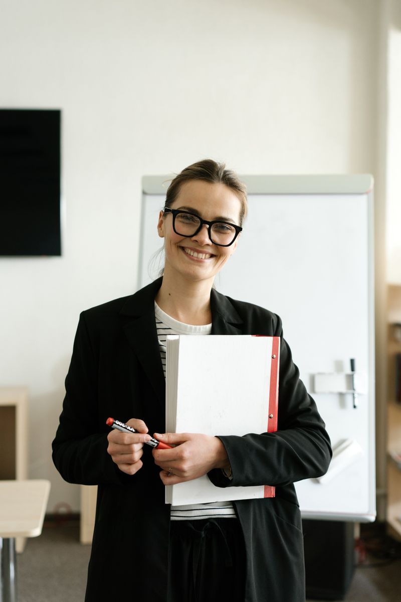Neha Agarwal holding a folder in a classroom